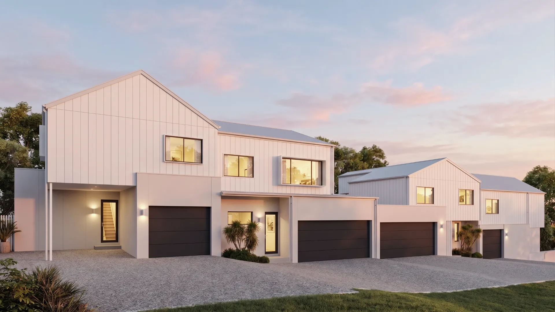 White two-story townhouses at dusk with warm lit windows